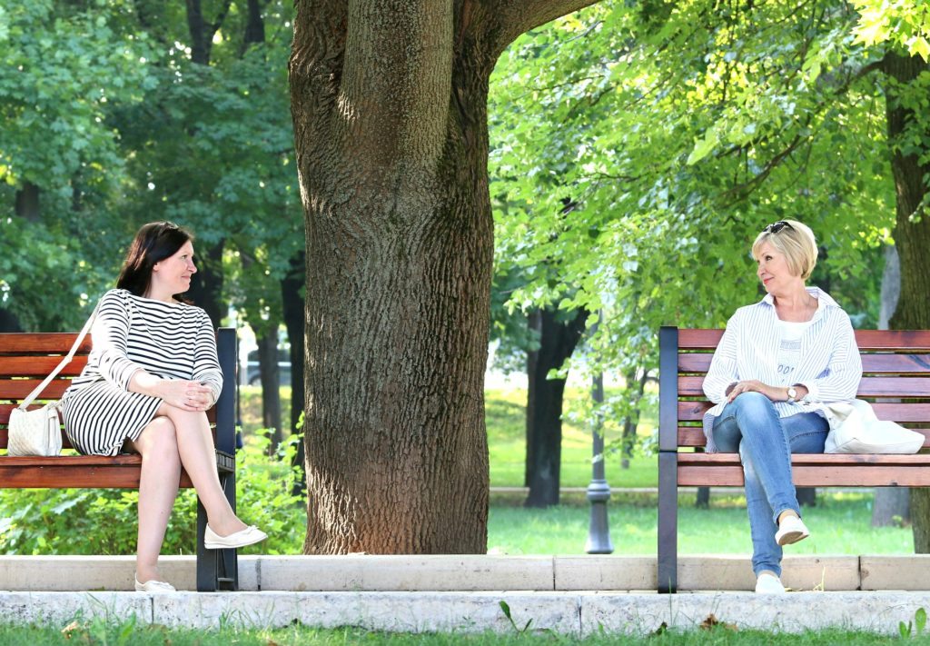 two women on separate park benches